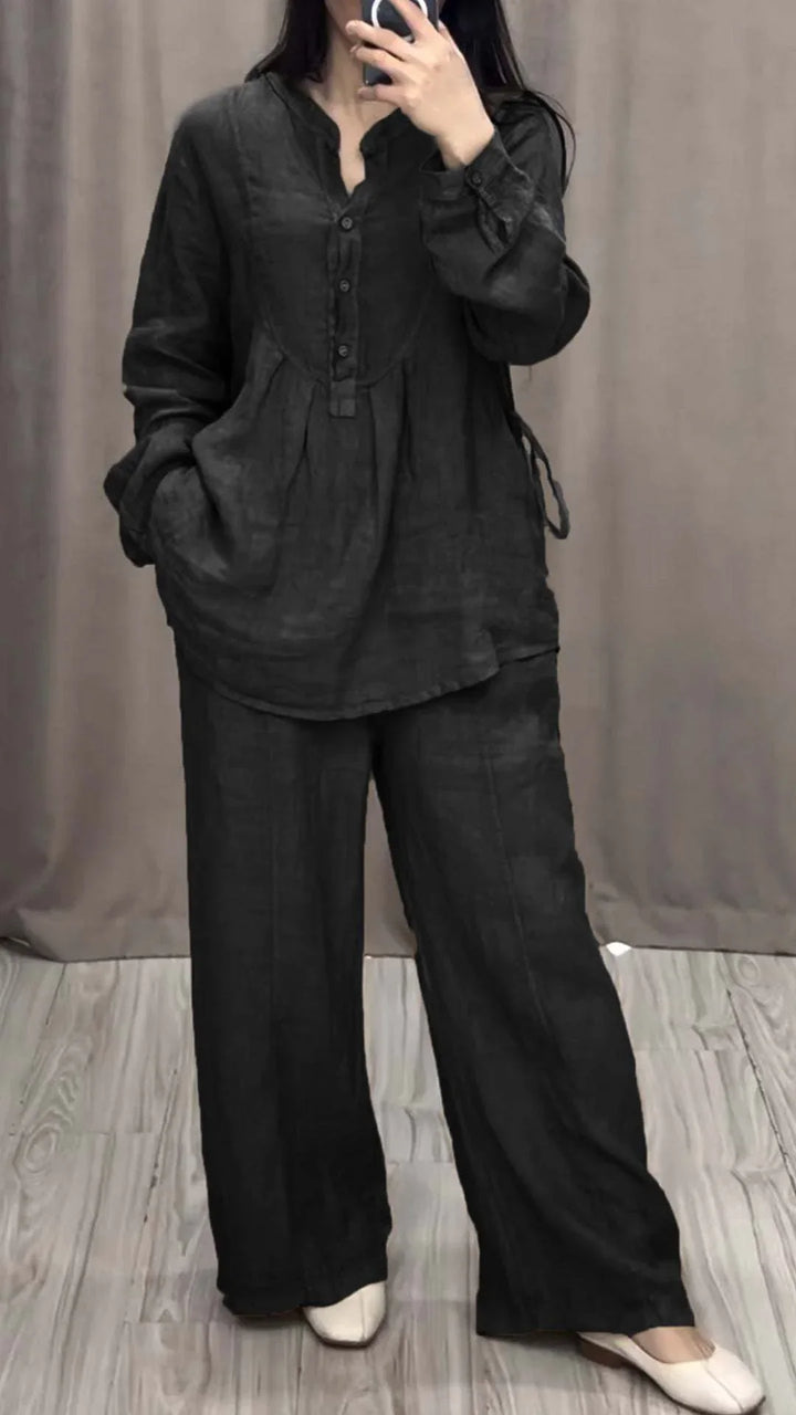 Woman wearing black linen long-sleeve blouse and wide-leg pants with white shoes in a fitting room