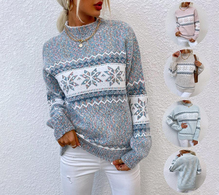 Woman wearing blue and white knit winter sweater with snowflake pattern and white pants