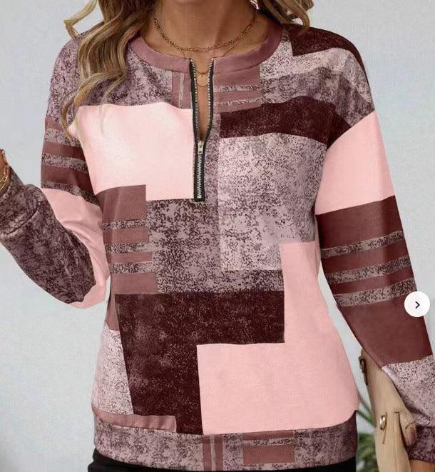 Woman wearing long-sleeve pink and brown geometric print top with half zipper and crew neckline