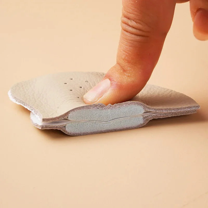 Finger pressing soft beige leather cushion pad showing thickness and flexible material