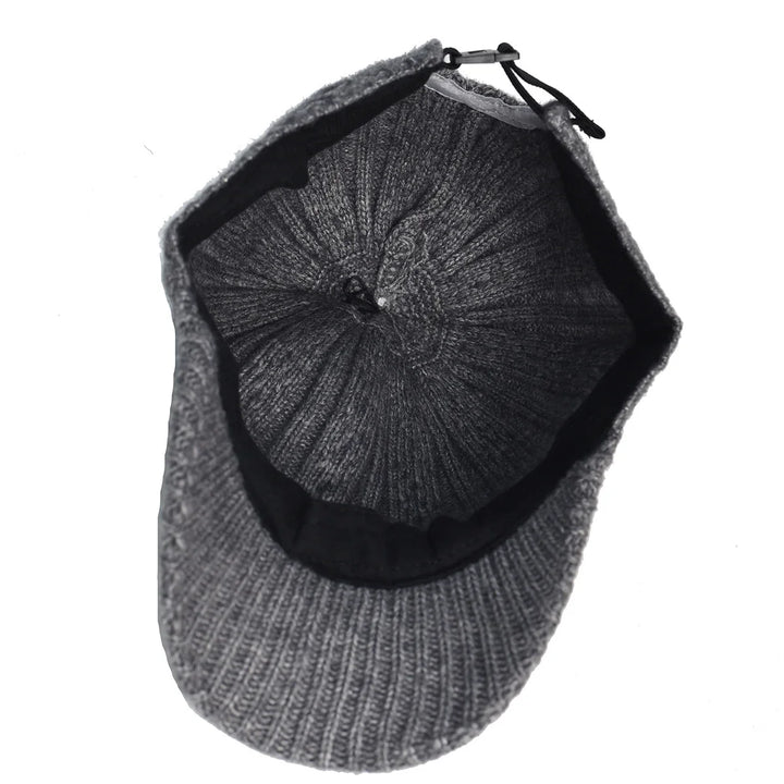 Top view of gray knitted winter cap with black inner lining and adjustable strap