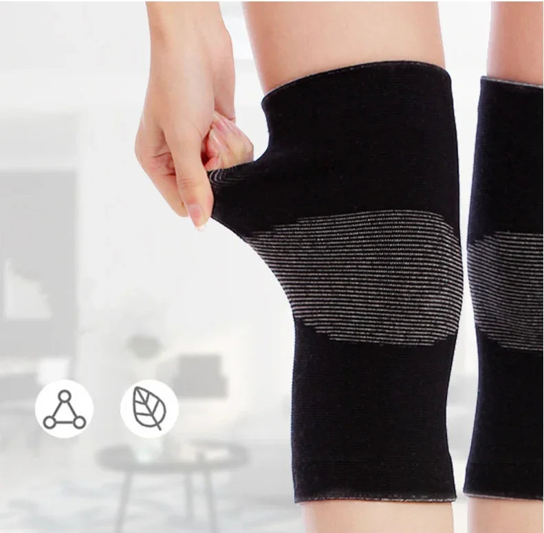 Person stretching black compression knee sleeve with gray stripes in a bright room