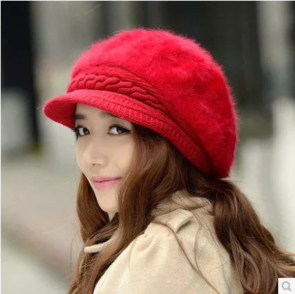Woman wearing a vibrant red knit beret with braided detail, beige coat, and long brown hair outdoors