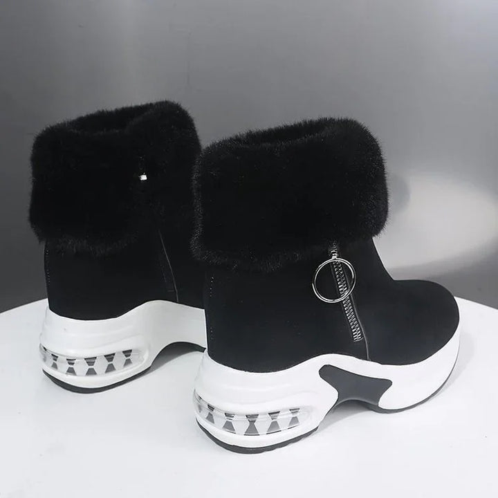Black ankle boots with white platform soles, faux fur cuffs, and round zipper pulls