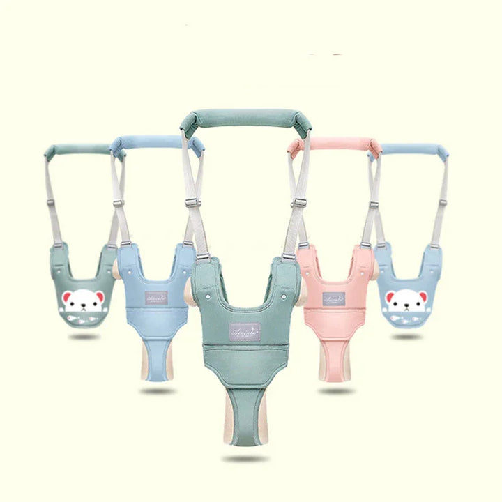 Baby walking harnesses in pink, blue, and green with adjustable straps and padded handles