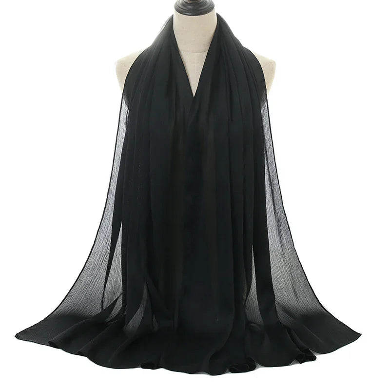 Elegant black chiffon scarf draped on mannequin with flowing, sheer fabric