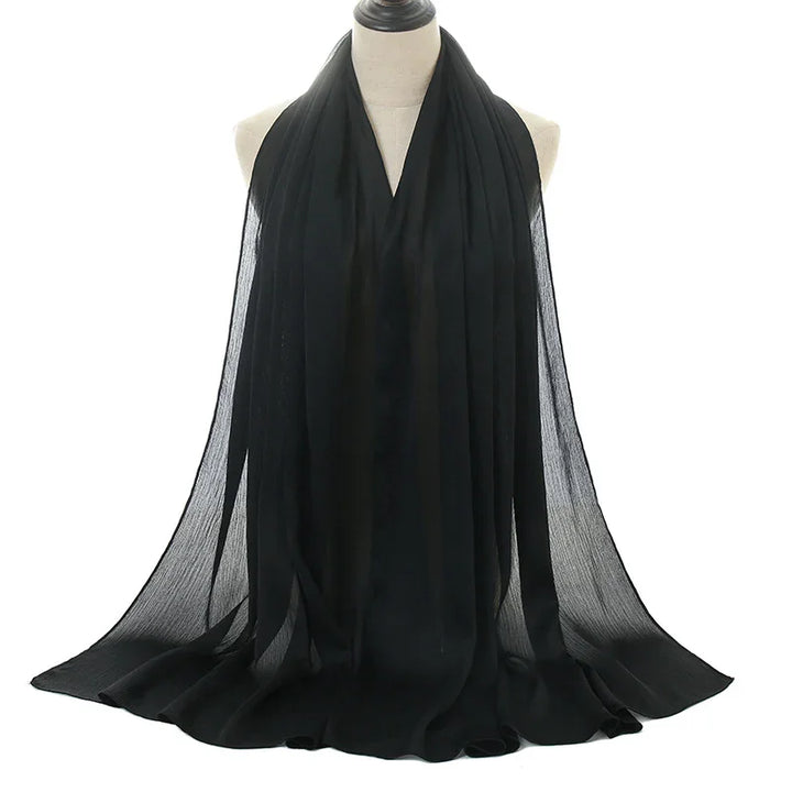 Elegant black chiffon scarf draped on mannequin with flowing, sheer fabric