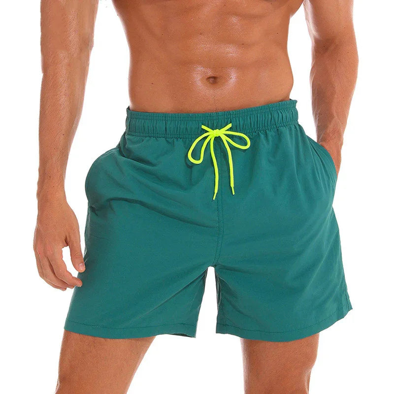 Men's green swim shorts with neon yellow drawstring on fit male model torso