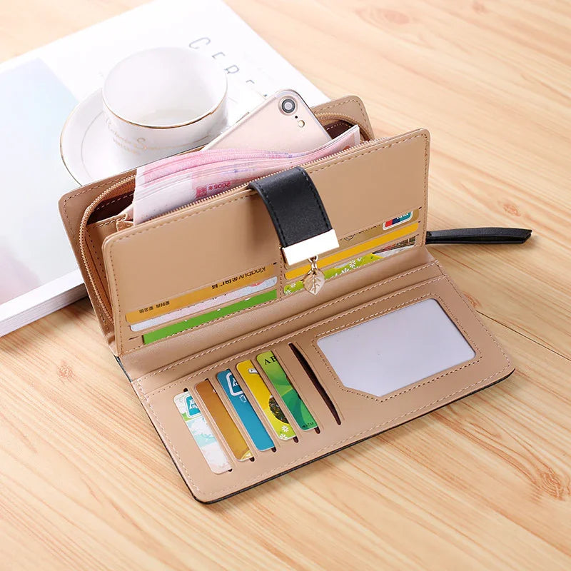 Beige leather wallet open on wooden table with multiple credit cards, cash, and a smartphone inside