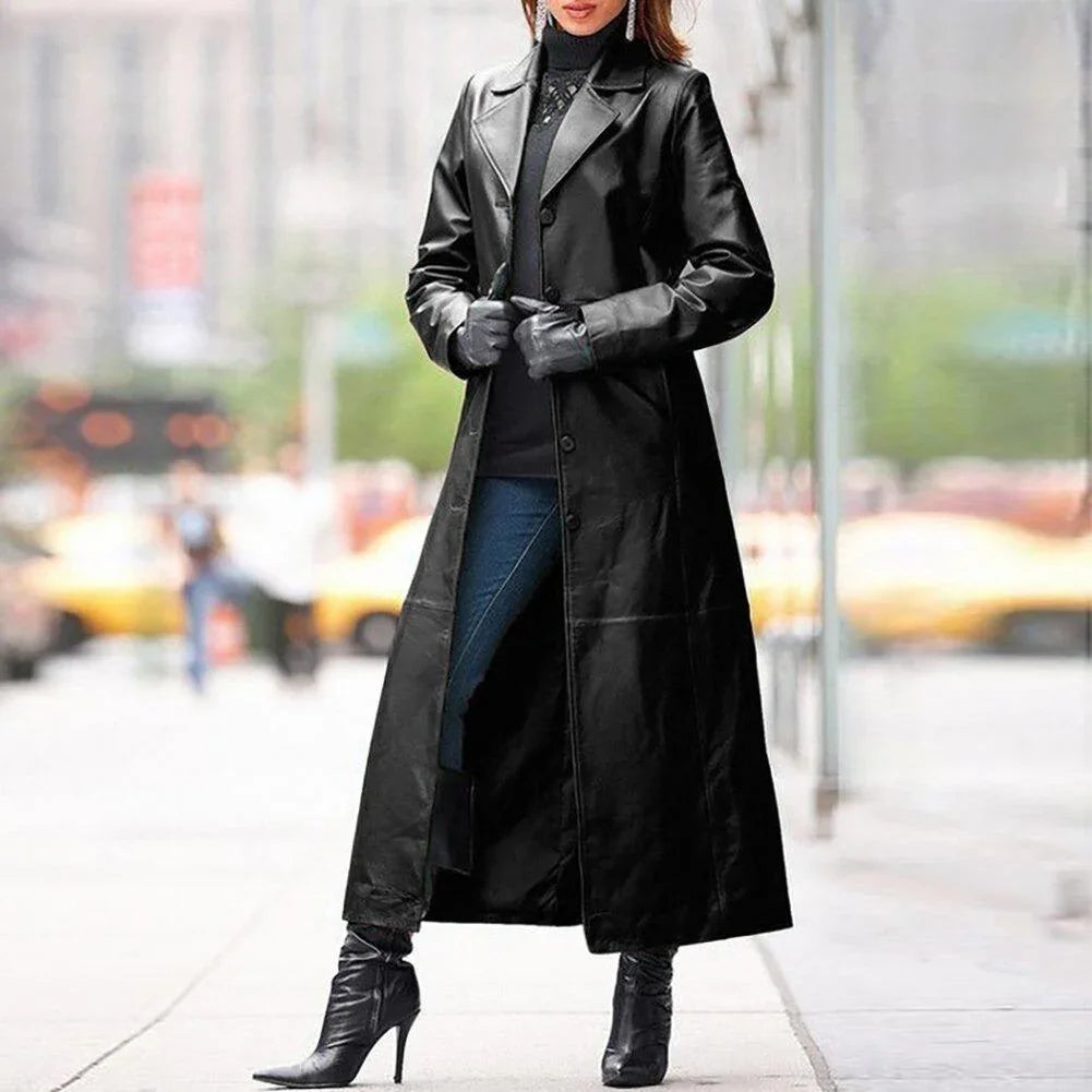 Woman in black long leather coat, gloves, and high-heeled boots on city sidewalk