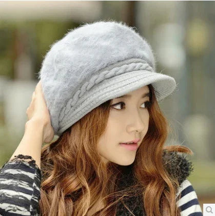 Young woman with long brown hair wearing a soft gray knitted hat and striped sweater in outdoor setting