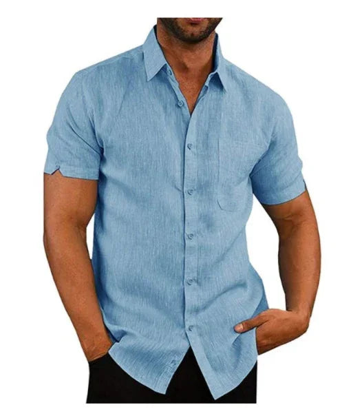 Man wearing light blue short-sleeve button-up shirt with collar, casual fit, hands in pockets