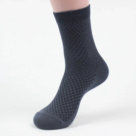 Single black textured ankle sock on foot with a subtle diamond pattern and ribbed cuff