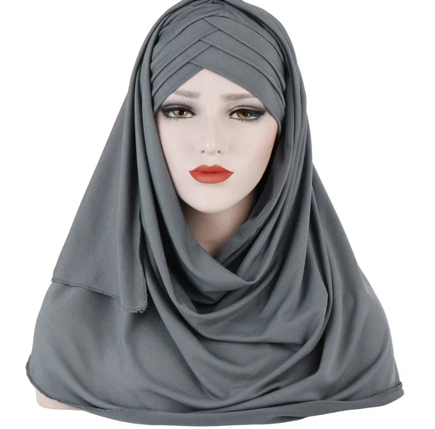 Mannequin wearing a draped grey hijab with pleated detailing on white background