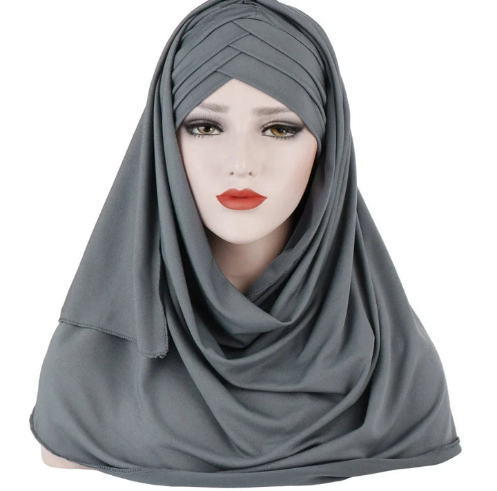 Mannequin wearing a draped grey hijab with pleated detailing on white background