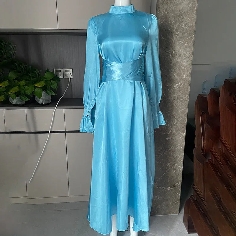 Light blue satin long-sleeve midi dress with high collar on mannequin indoors