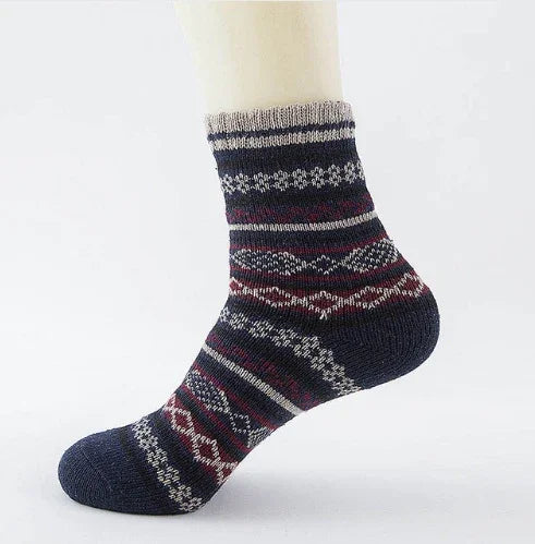 Navy blue wool sock with red, white, and gray geometric patterns on a mannequin foot