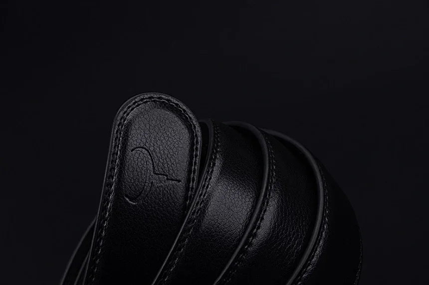Close-up of black leather belt rolls with textured finish and embossed logo on dark background
