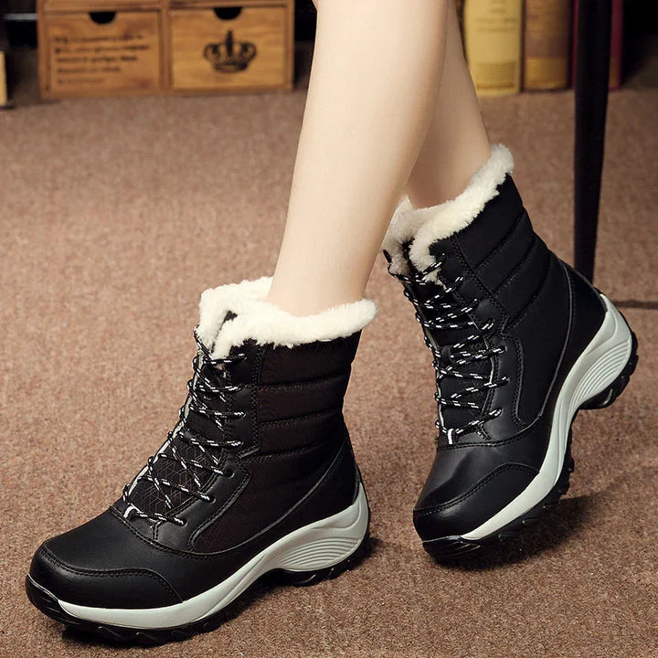 Black winter boots with white fur lining and lace-up design on carpeted floor