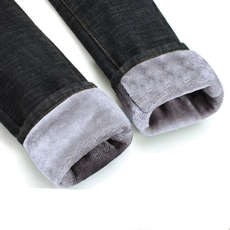 Close-up of black denim jeans with soft grey fleece lining inside the cuffs for winter warmth