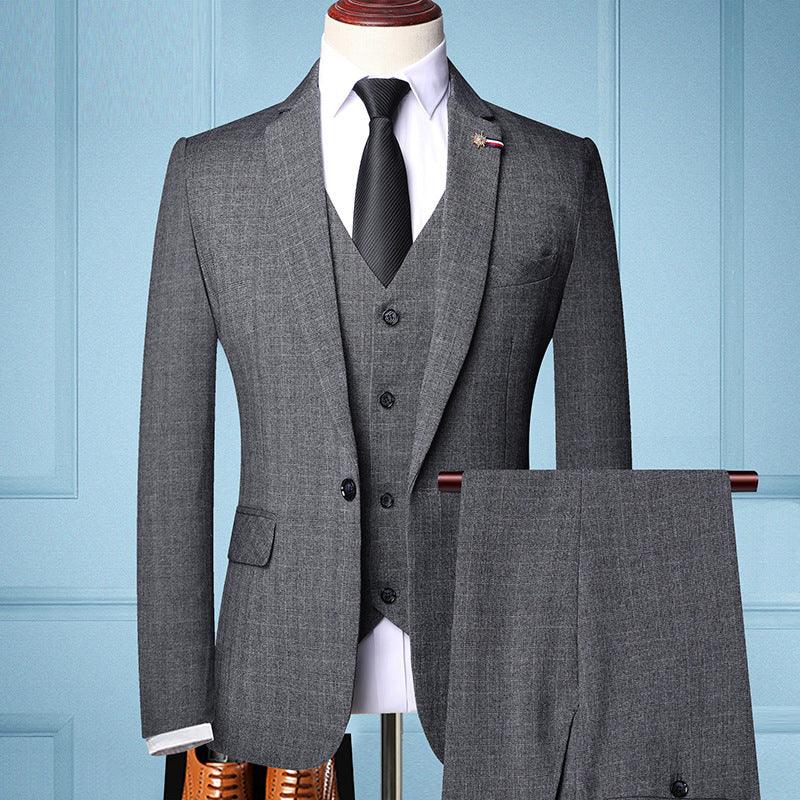 Gray three-piece men's suit with black tie on mannequin and matching trousers on hanger