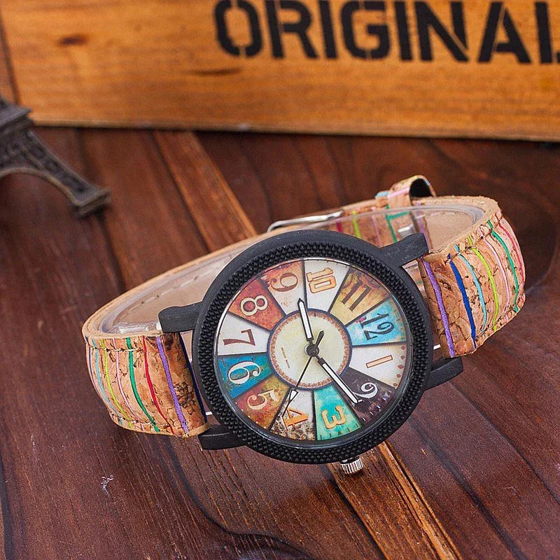 Vintage-style wristwatch with multicolor numbered dial and brown stitched leather strap on wooden surface