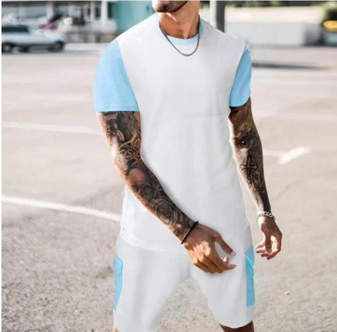 Man wearing white and light blue tattoo sleeve casual t-shirt and shorts outfit outdoors