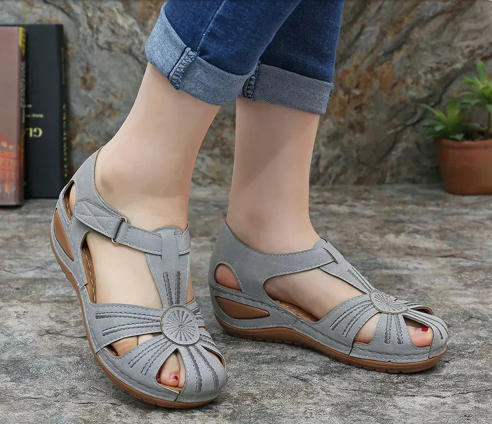 Women's casual gray leather sandals with open toe and cutout design on stone floor