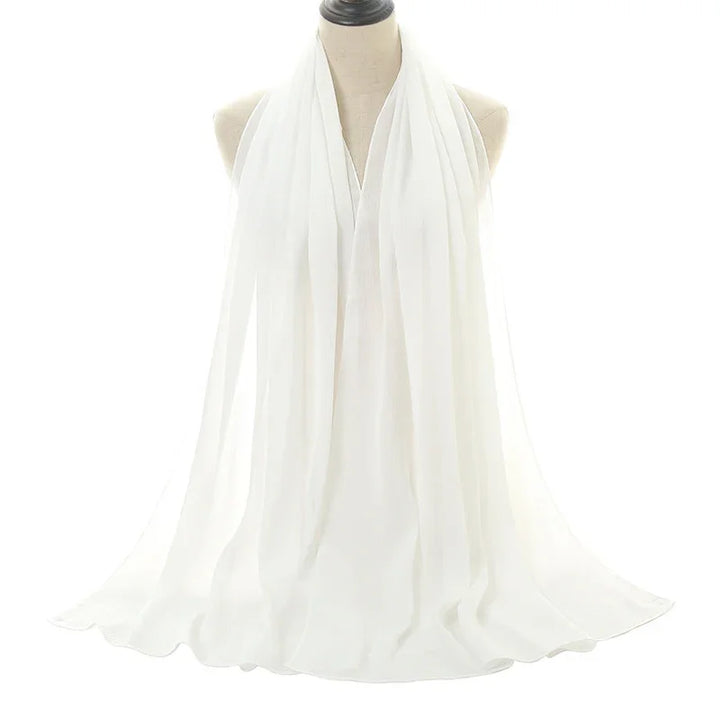 Elegant white chiffon scarf draped on a dress form against a white background