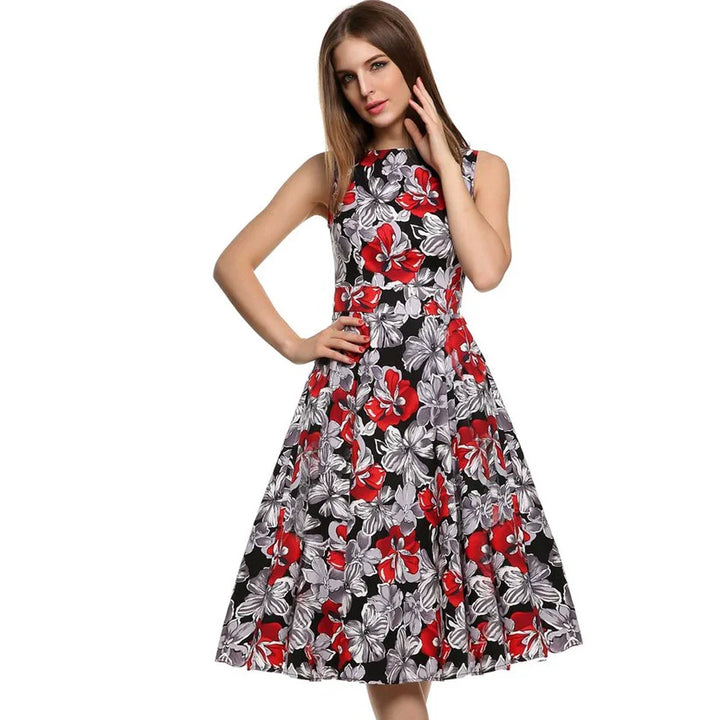 Woman wearing sleeveless black midi dress with red and gray floral print posing with hand on hip