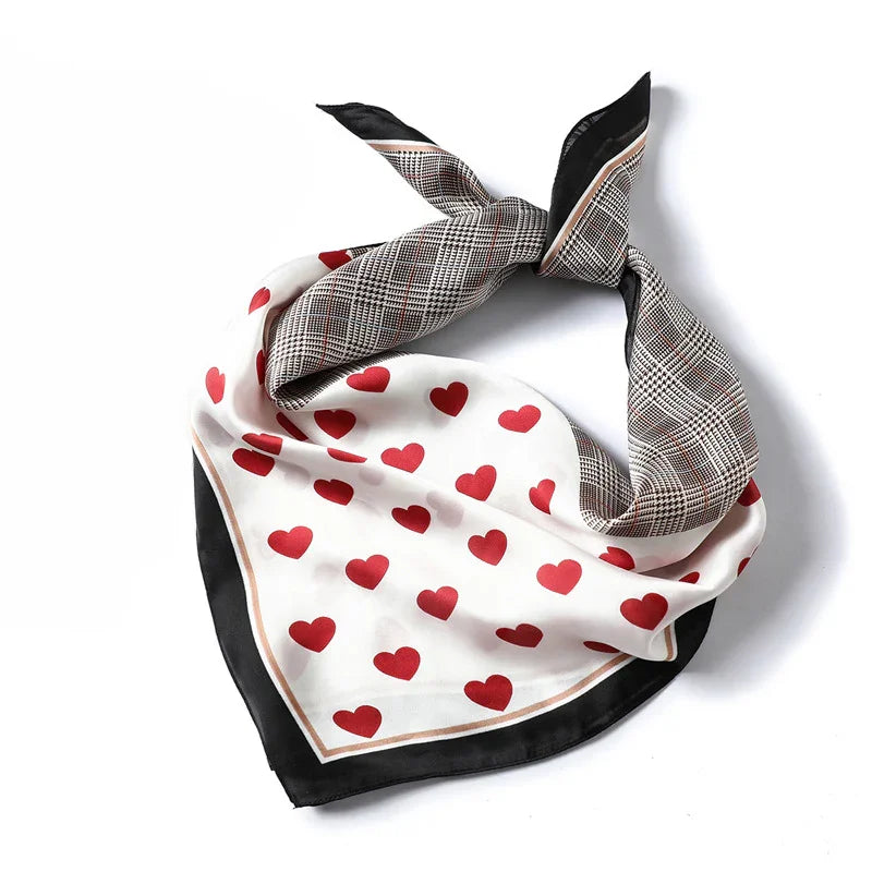 Silk scarf with red heart pattern on white and plaid design on black, folded on white background