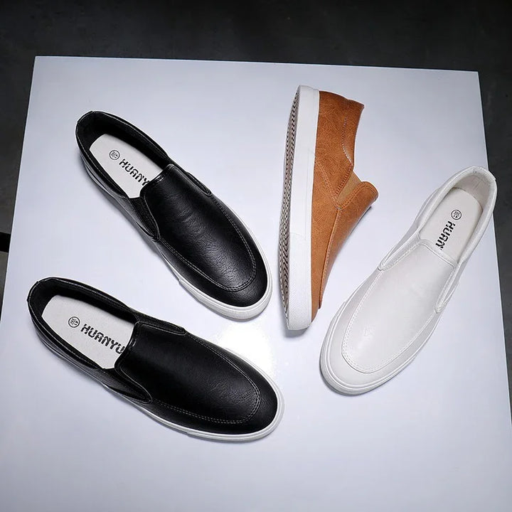 Casual slip-on shoes in black, white, and brown on white background, stylish and comfortable footwear