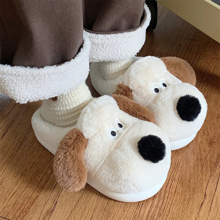 Cozy plush dog slippers with brown ears and black noses worn with cream socks on wooden floor