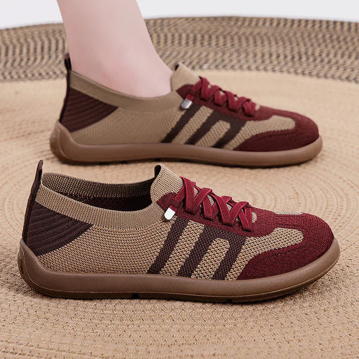 Brown and burgundy knitted casual sneakers with three dark stripes on beige woven rug