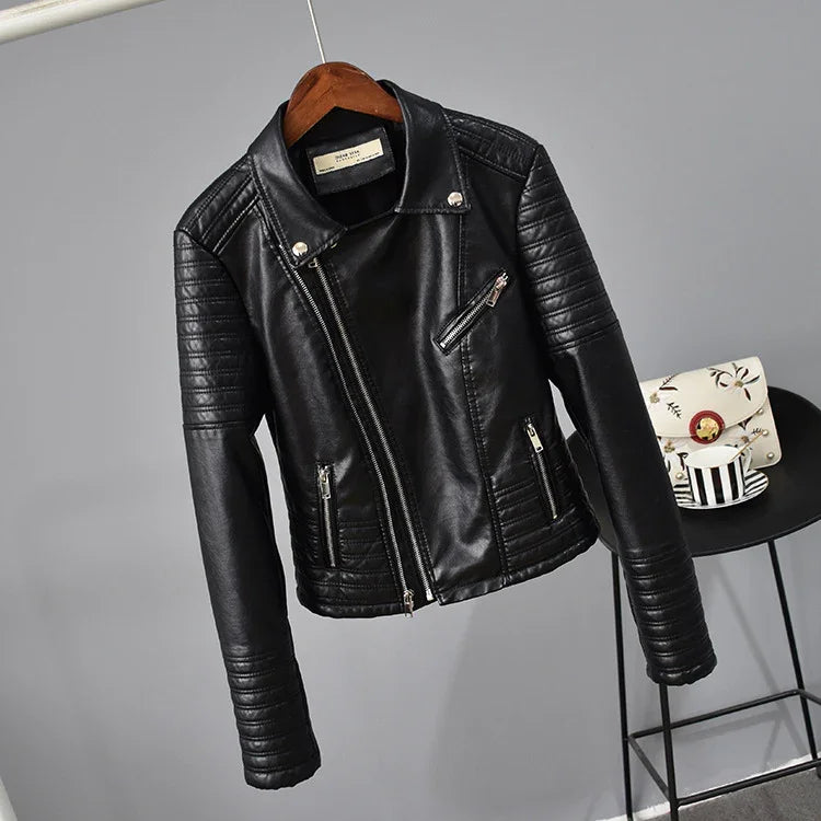 Black faux leather biker jacket with quilted sleeves and silver zippers hanging on wooden hanger