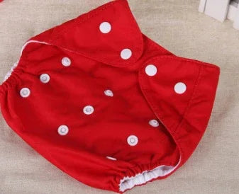 Red baby cloth diaper with white snap buttons, elastic edges on beige fabric background