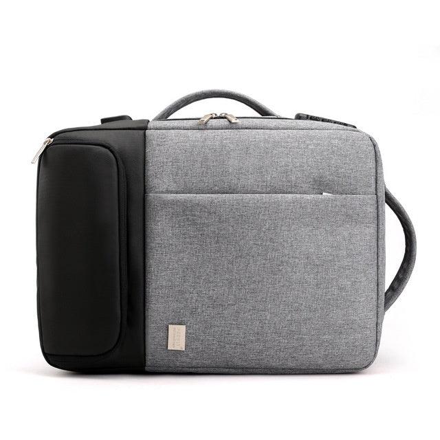 Gray and black laptop backpack with front pockets and carrying handle on white background