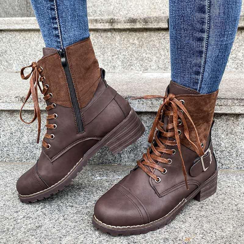 Brown lace-up ankle boots with zipper and buckle worn with blue jeans on stone steps