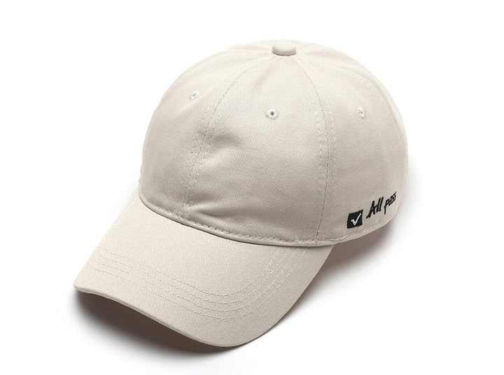 Light beige baseball cap with small black checkmark and text on side against white background