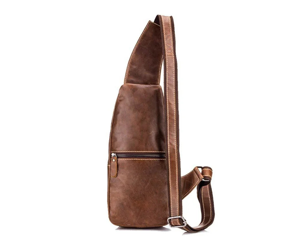 brown leather sling bag with zipper pocket and adjustable shoulder strap on white background