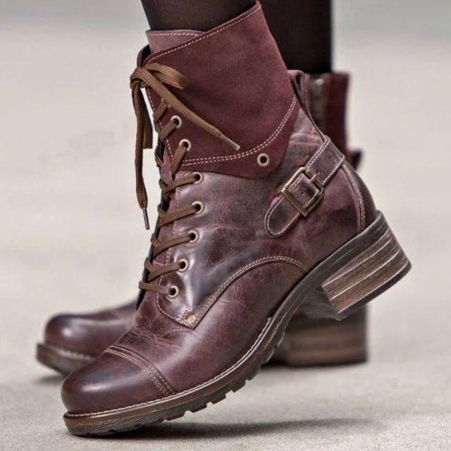 close-up of brown leather lace-up ankle boots with buckle detail and stacked heel