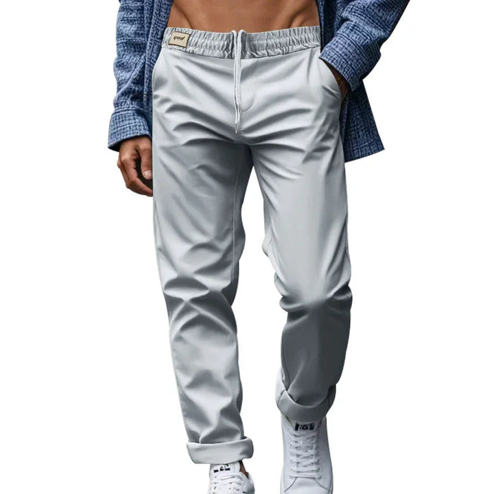 man wearing light gray jogger pants with elastic waistband and white sneakers