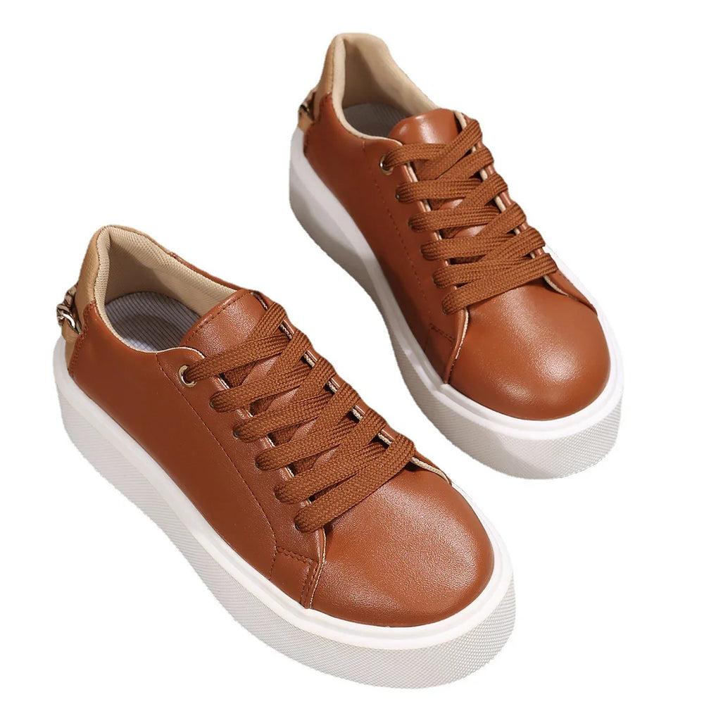 Brown leather sneakers with thick white rubber soles and brown laces on white background