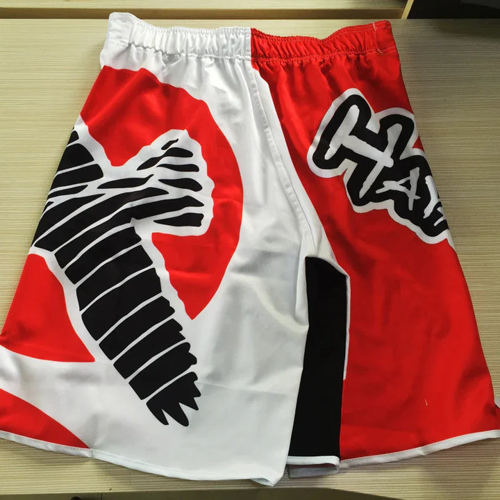 Red and white fight shorts with black crow graphic and bold HA design on table