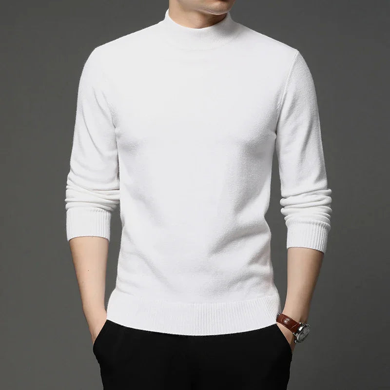Man wearing a white long-sleeve mock neck sweater with black pants and a wristwatch