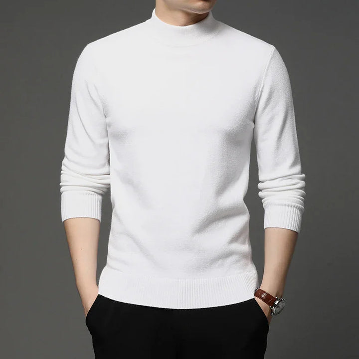 Man wearing a white long-sleeve mock neck sweater with black pants and a wristwatch