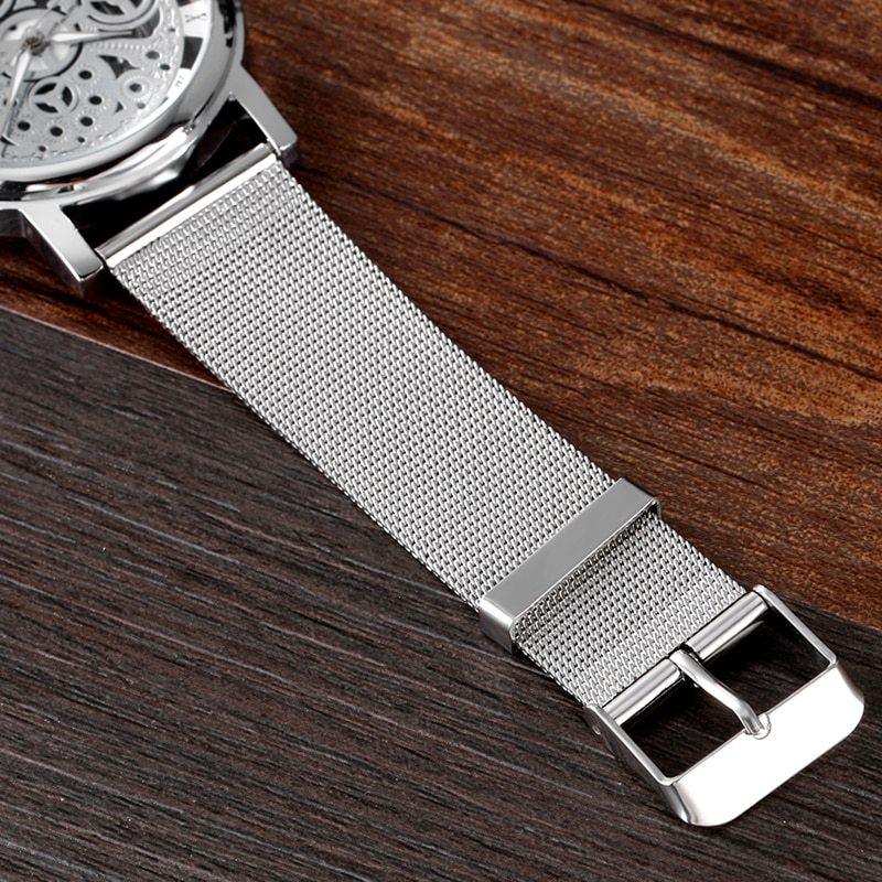 Silver stainless steel mesh watch strap with buckle on wooden surface