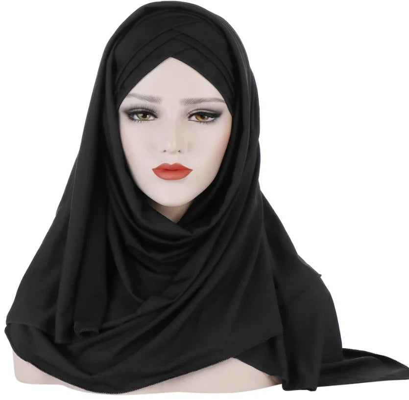 Mannequin head wearing a black layered hijab with makeup on a white background
