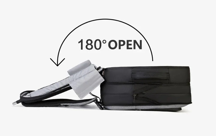 Black and gray backpack laying flat with shoulder straps opened 180 degrees against white background