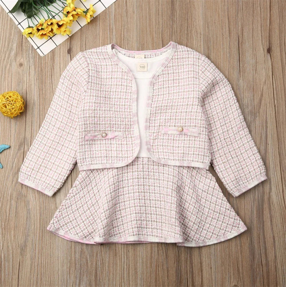 Pink and white plaid toddler girl dress with matching cropped jacket on wood background